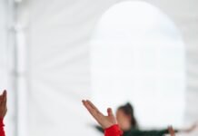 직장인과 주부에게 스트레칭이 필요한 이유 woman in red long sleeve shirt raising her hands