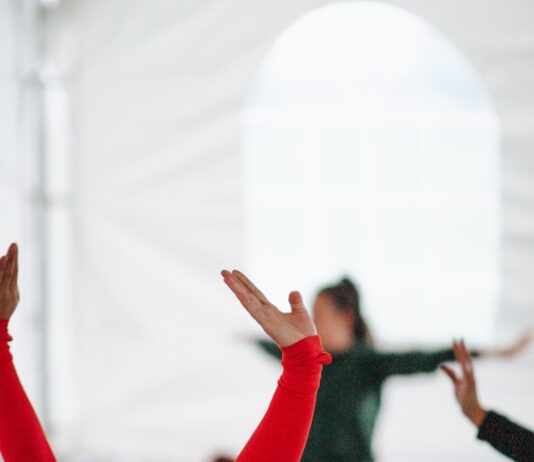 직장인과 주부에게 스트레칭이 필요한 이유 woman in red long sleeve shirt raising her hands