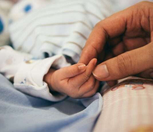 육아기 근로시간 단축 자녀 나이 ‘12세 이하’로 확대 person holding baby's index finger