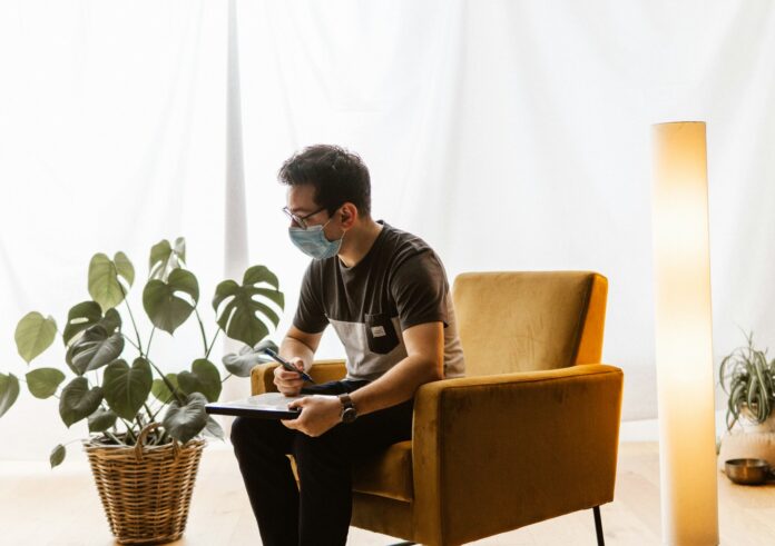 Photo by Leuchtturm Entertainment a man sitting in a chair wearing a face mask