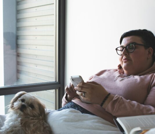 WHO, “비만은 만성질환”… 체중감량 약물 사용 권고 지침 발표 person holding smartphone beside dog