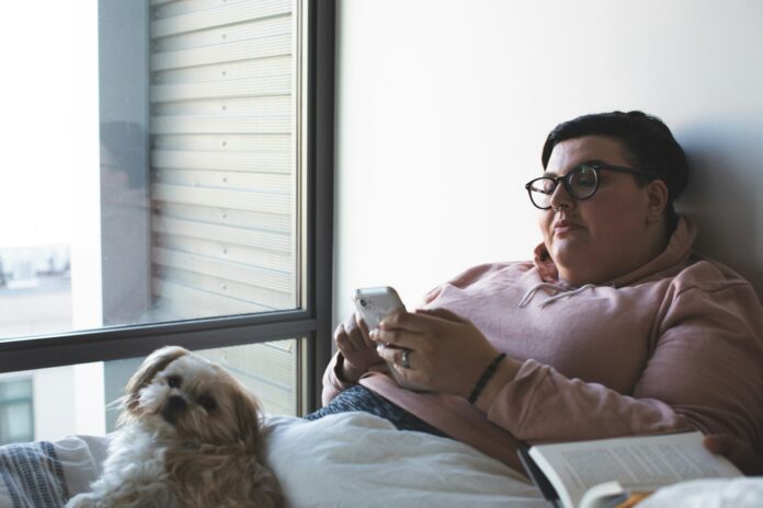 Photo by AllGo - An App For Plus Size People person holding smartphone beside dog