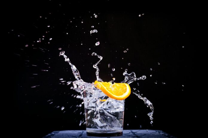 Photo by Thao LEE splash of water in drinking glass with sliced lemon